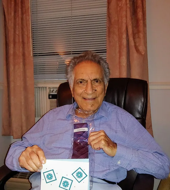 Ishwar Puri seated in an armchair, wearing a lavender shirt